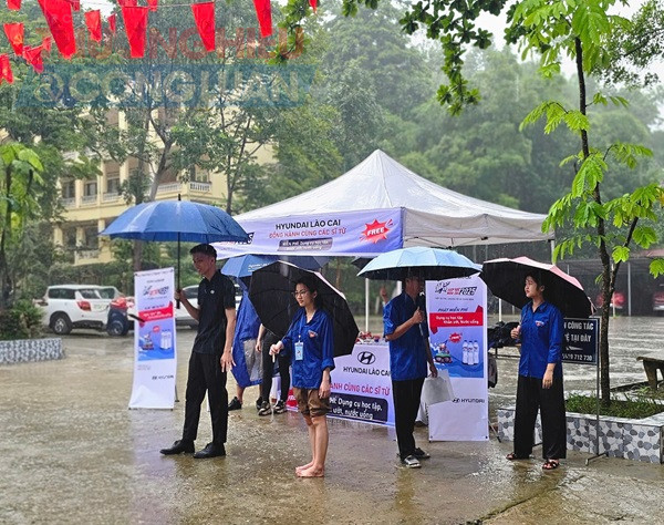 Một chiếc bàn nhỏ bên lối vào trở thành “trạm dừng chân” cho các bạn tình nguyện viên và thí sinh. Nước uống, đồ ăn nhẹ, thước kẻ, quạt giấy… được chuẩn bị sẵn sàng, trao tận tay thí sinh