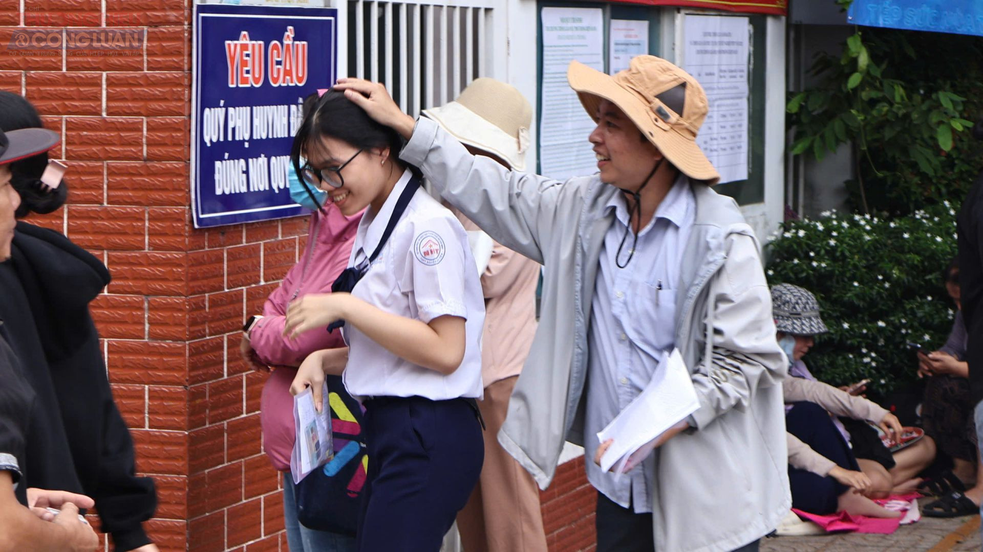 Không chỉ phụ huynh động viên tinh thần con mà giáo viên chủ nhiệm cũng ủng hộ các thí sinh làm bài tốt. (Ảnh: Mai Dung)