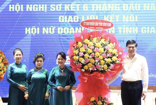 Ông Lâm Hải Giang (bìa phải) tặng hoa cho lãnh đạo Hội NDN Bình Định.