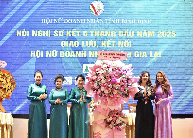 Chị Trần Thị Kim Hoa (thứ 2 từ phải qua) tặng hoa chúc mừng Hội NDN Bình Định.