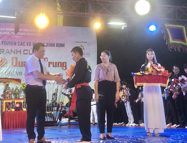 Ông Bùi Trung Hiếu (bìa trái) tặng hoa VĐV. Ảnh: Viết Hiền