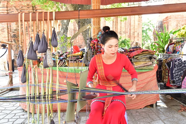 Thiếu nữ Chăm biểu diễn dệt thổ cẩm phục vụ du khách tại Tháp Bà Ponagar