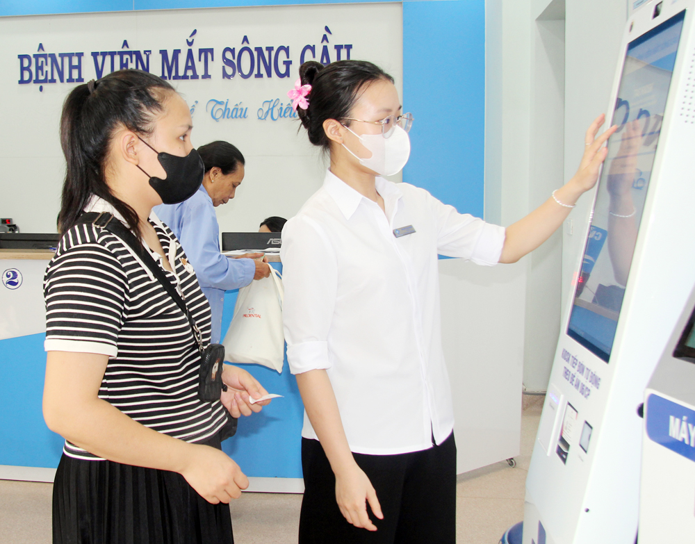 Người dân đăng ký khám bệnh bằng máy lấy số tự động tại Bệnh viện Mắt Sông Cầu.