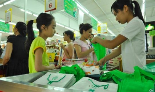 Túi thân thiện với môi trường (túi giấy trắng hoặc túi vải xanh) phát miễn phí tại một hệ thống siêu thị trên địa bàn Thủ đô. (Ảnh: Quang Xuân)
