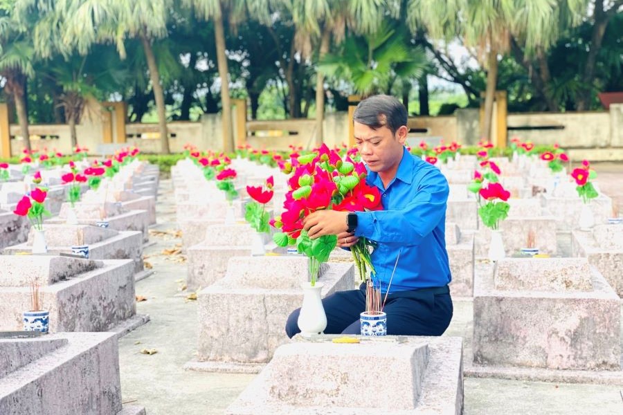 Cán bộ, đoàn viên thanh niên tiến hành thay mới hoa sen trên các phần mộ anh hùng liệt sĩ tại nghĩa trang.