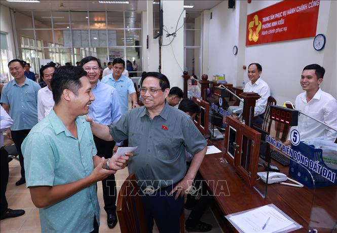 Thủ tướng Phạm Minh Chính thăm hỏi người dân đến làm thủ tục tại Trung tâm Phục vụ hành chính công phường Ninh Kiều. Ảnh: Dương Giang/TTXVN