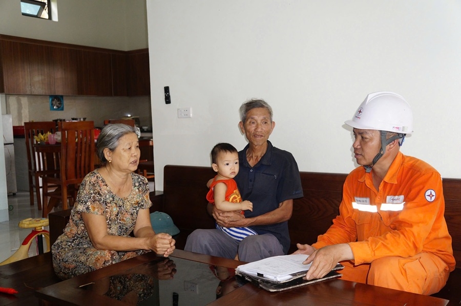 Công nhân Đội Quản lý Điện lực khu vực Hậu Lộc tư vấn khách hàng về sử dụng điện an toàn, tiết kiệm và hiệu quả