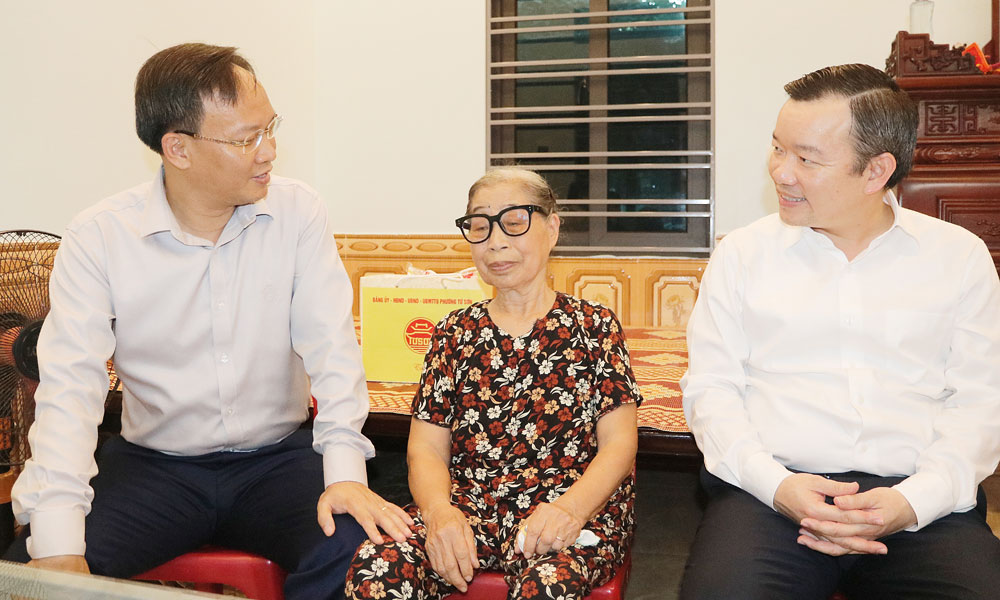 Đồng chí Phạm Văn Thịnh (trái) thăm hỏi bà Nguyễn Thị Thêm.