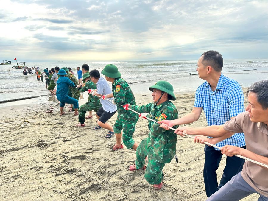 Hỗ trợ ngư dân kéo thuyền bị nạn vào bờ.