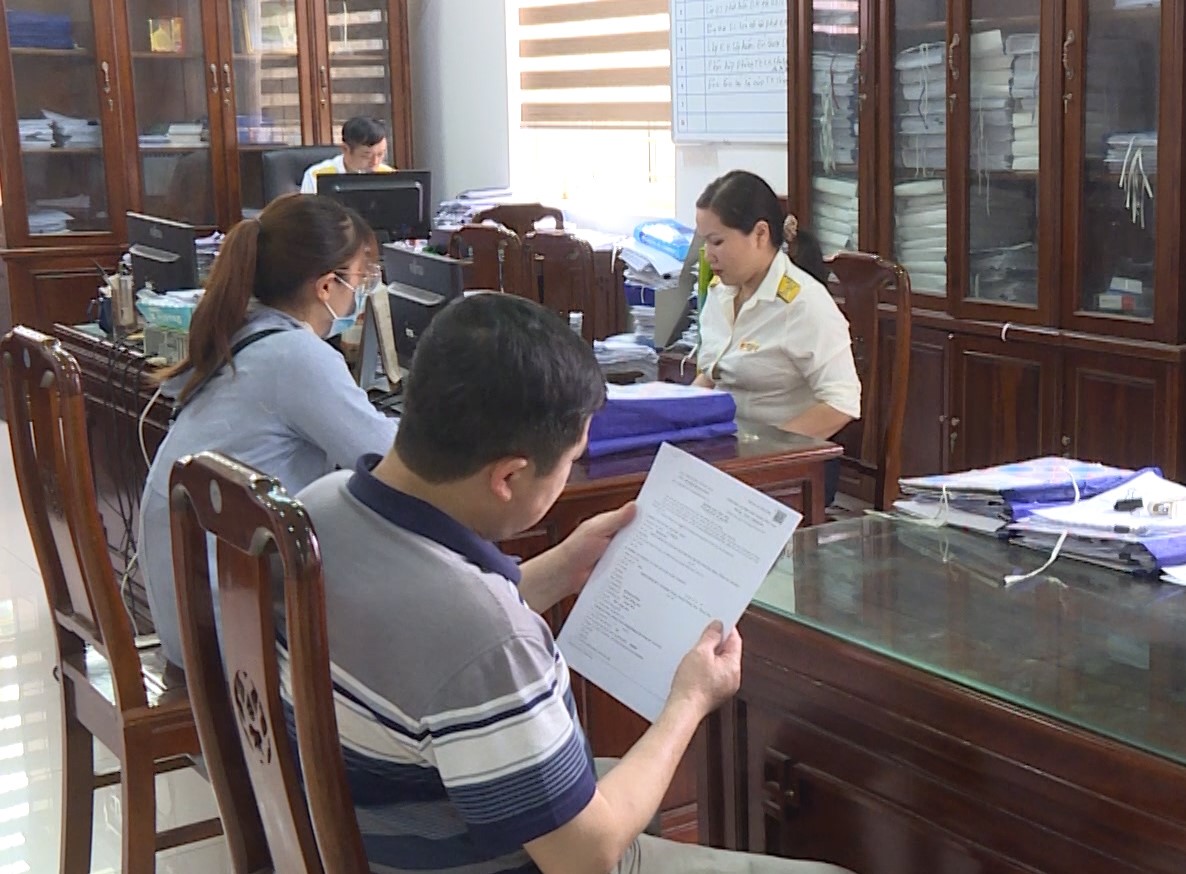 Công chức Thuế tỉnh Thanh Hóa hỗ trợ người dân làm thủ tục nộp thuế. Ảnh: THTH