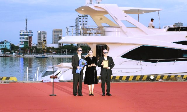 Phó Chủ tịch UBND TP. Đà Nẵng bà Nguyễn Thị Anh Thi (giữa) tặng hoa và kỷ niệm chương cho hai nhà thiết kế.