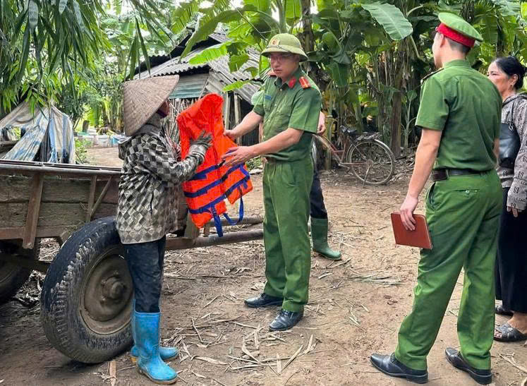 Công an xã Cẩm Khê tặng áo phao và tuyên truyền cho người dân về biện pháp trú tránh bão.