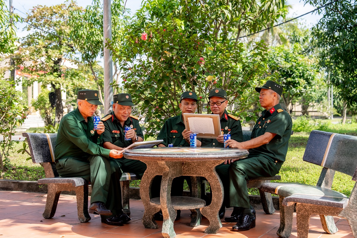Các bác cựu chiến binh chăm chú đọc những dòng chữ nhỏ, được các em gửi kèm trong mỗi bức tranh (Ảnh: Duy Cường).