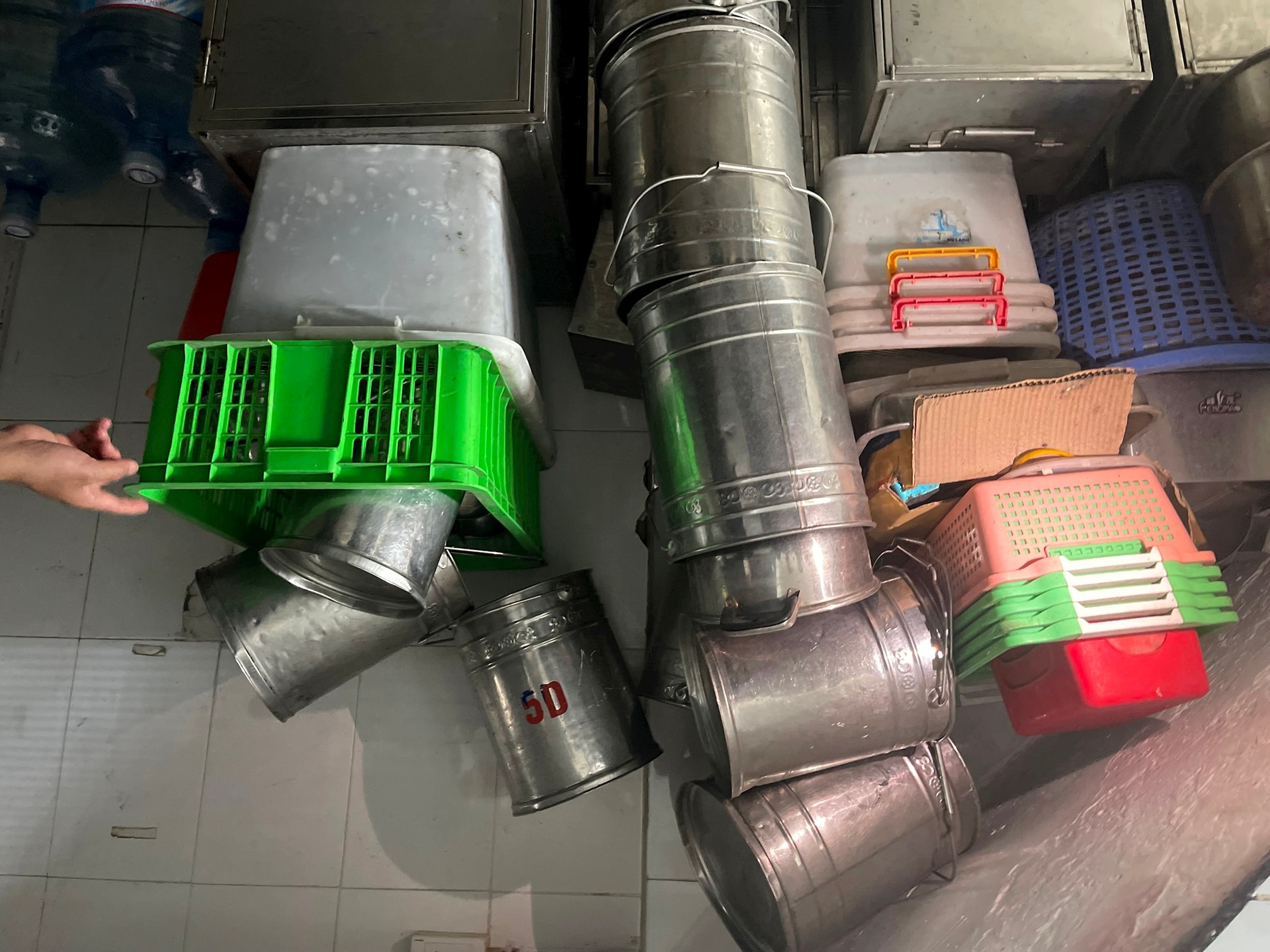 Các dụng cụ như: Xô inox, chậu nhựa, khay đựng thực phẩm… không có tủ bảo quản. Ảnh: Thu Trang