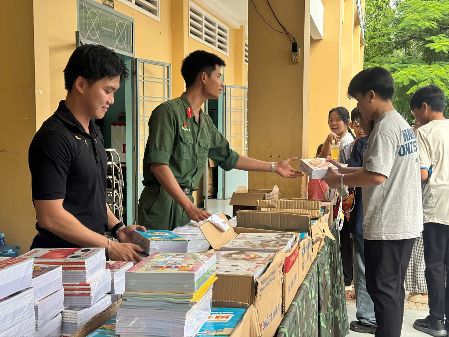 Các chiến sĩ đang tặng tập vở cho học sinh Các chiến sĩ đang tặng tập vở cho học sinh