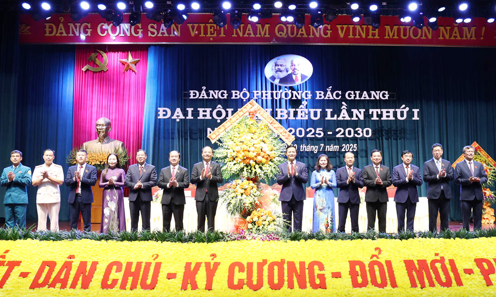 Đồng chí Vương Quốc Tuấn và các đồng chí lãnh đạo tỉnh tặng hoa chúc mừng Đại hội.