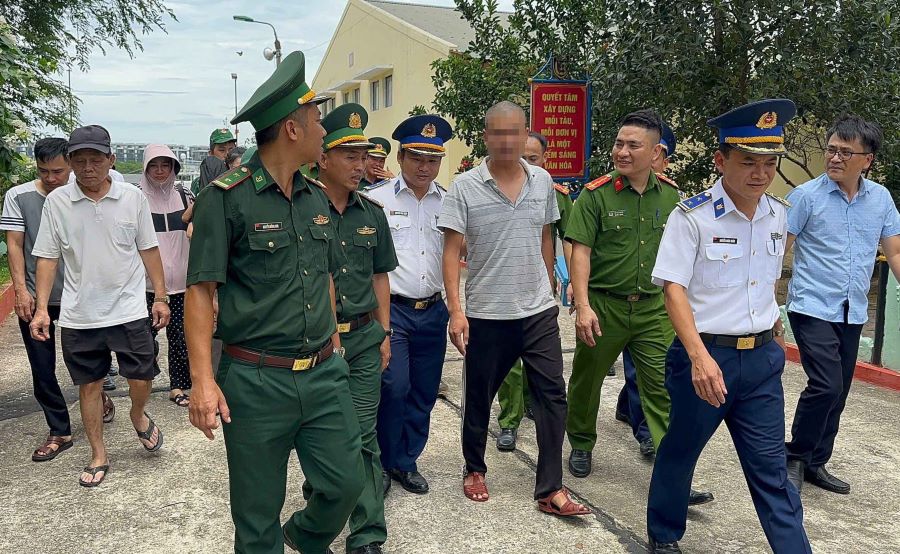 Cơ quan chức năng đưa bố con anh T. vào bờ an toàn.