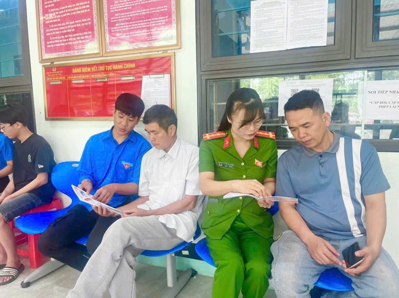 Công an xã và đoàn viên thanh niên hướng dẫn người dân cách quét mã QR cuốn sổ