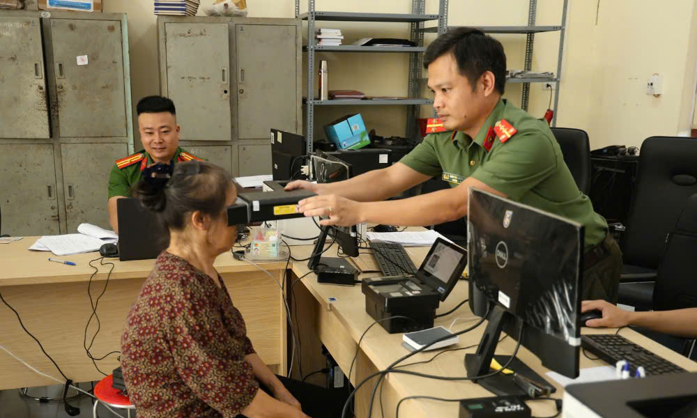 Cán bộ Công an xã Tân Chi thu thập sinh trắc học mống mắt cho đảng viên đổi thẻ.