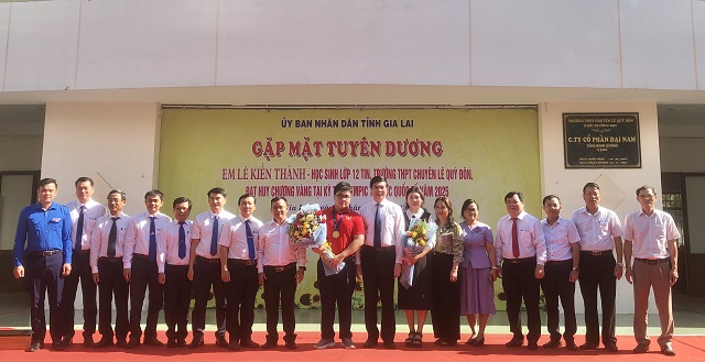 Em Lê Kiên Thành (áo đỏ, đứng giữa) chụp ảnh lưu niệm cùng lãnh đạo UBND tỉnh, các sở, ban, ngành, đoàn thể và các nhà tài trợ. Ảnh: VH