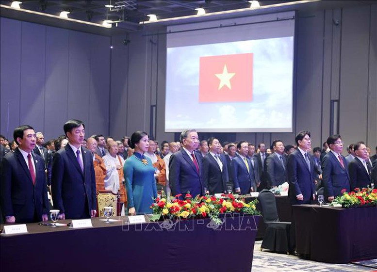 Tổng Bí thư Tô Lâm và Phu nhân, cùng các đại biểu tham dự buổi lễ thực hiện nghi thức chào cờ - Ảnh: TTXVN