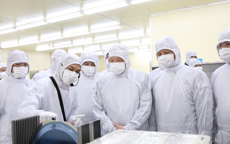 Phó Thủ tướng Thường trực Chính phủ Nguyễn Hòa Bình nghe giới thiệu các sản phẩm khi thăm Công ty TNHH Hana Micron Vina - Ảnh: VGP/Nguyễn Hoàng