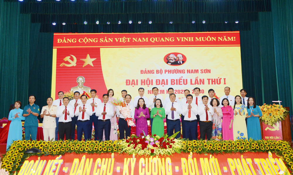 Đồng chí Nguyễn Thị Hương và các đại biểu tặng hoa chúc mừng Ban Chấp hành Đảng bộ phường Nam Sơn nhiệm kỳ 2025-2030.