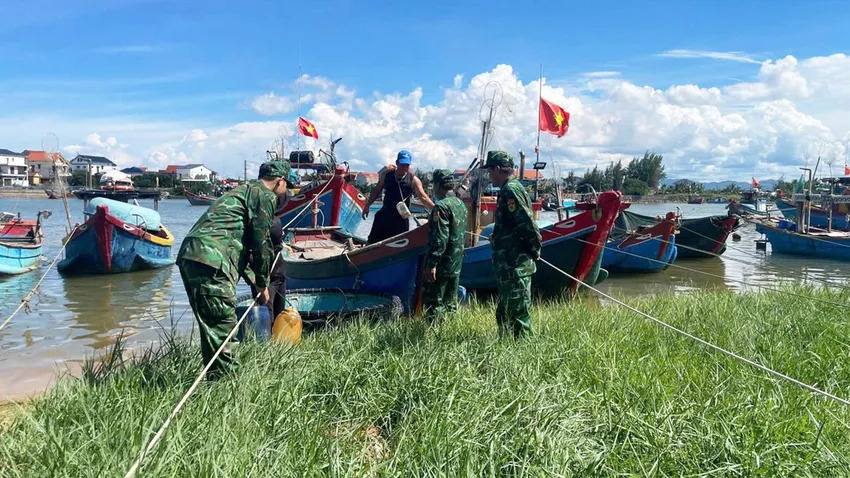 3. Cán bộ, chiến sĩ Đồn Biên phòng Lý Hòa (Bộ đội Biên phòng Quảng Trị) hỗ trợ chằng buộc phương tiện cho ngư dân. Ảnh: BĐBP