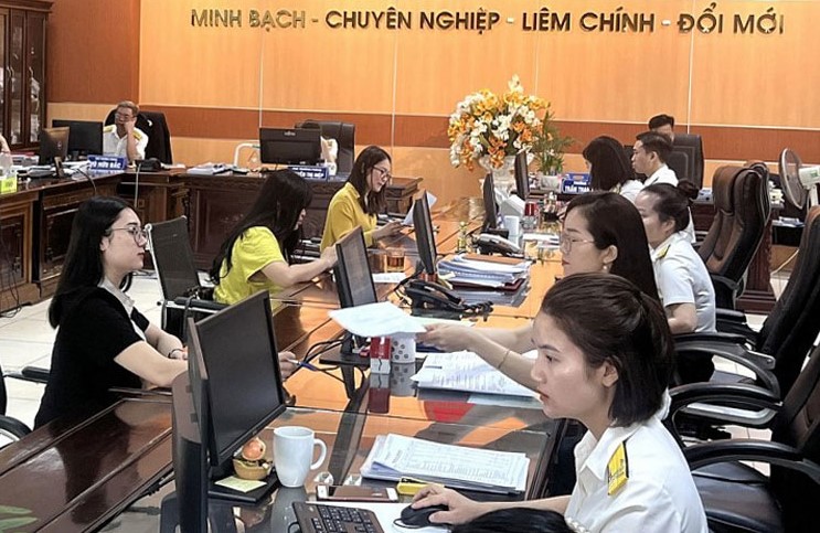 Công chức Thuế tỉnh Thái Nguyên hỗ trợ người dân làm thủ tục nộp thuế. Ảnh: KT