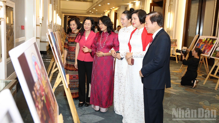 Các đại biểu xem tranh ảnh trưng bày tại chương trình. (Ảnh: KHÁNH LAN)