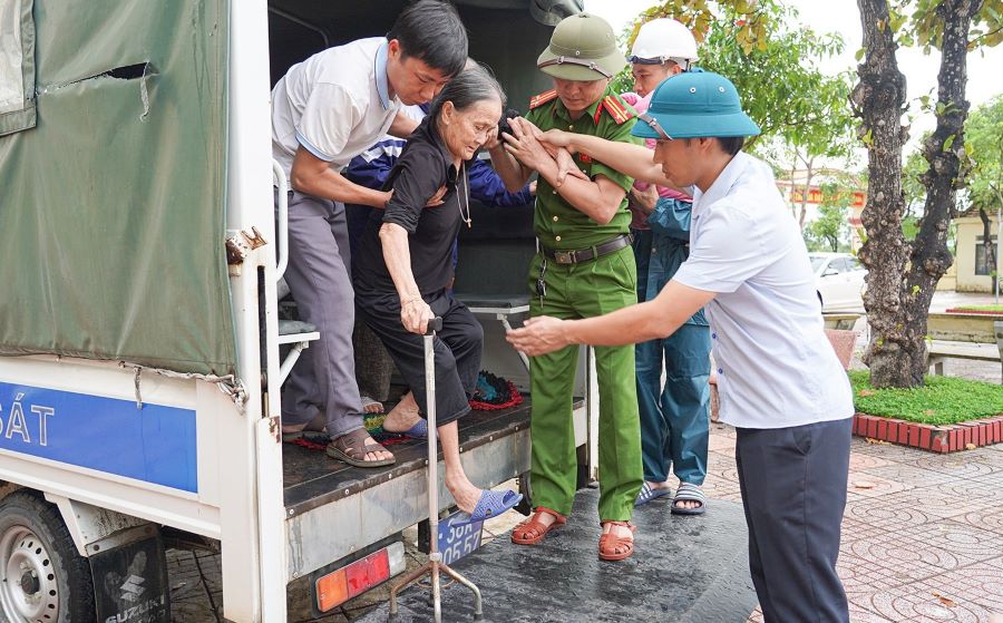 Các lực lượng vũ chức năng hỗ trợ người dân, nhất là người già, trẻ em, người ốm đau, bệnh tật đến địa điểm sơ tán.