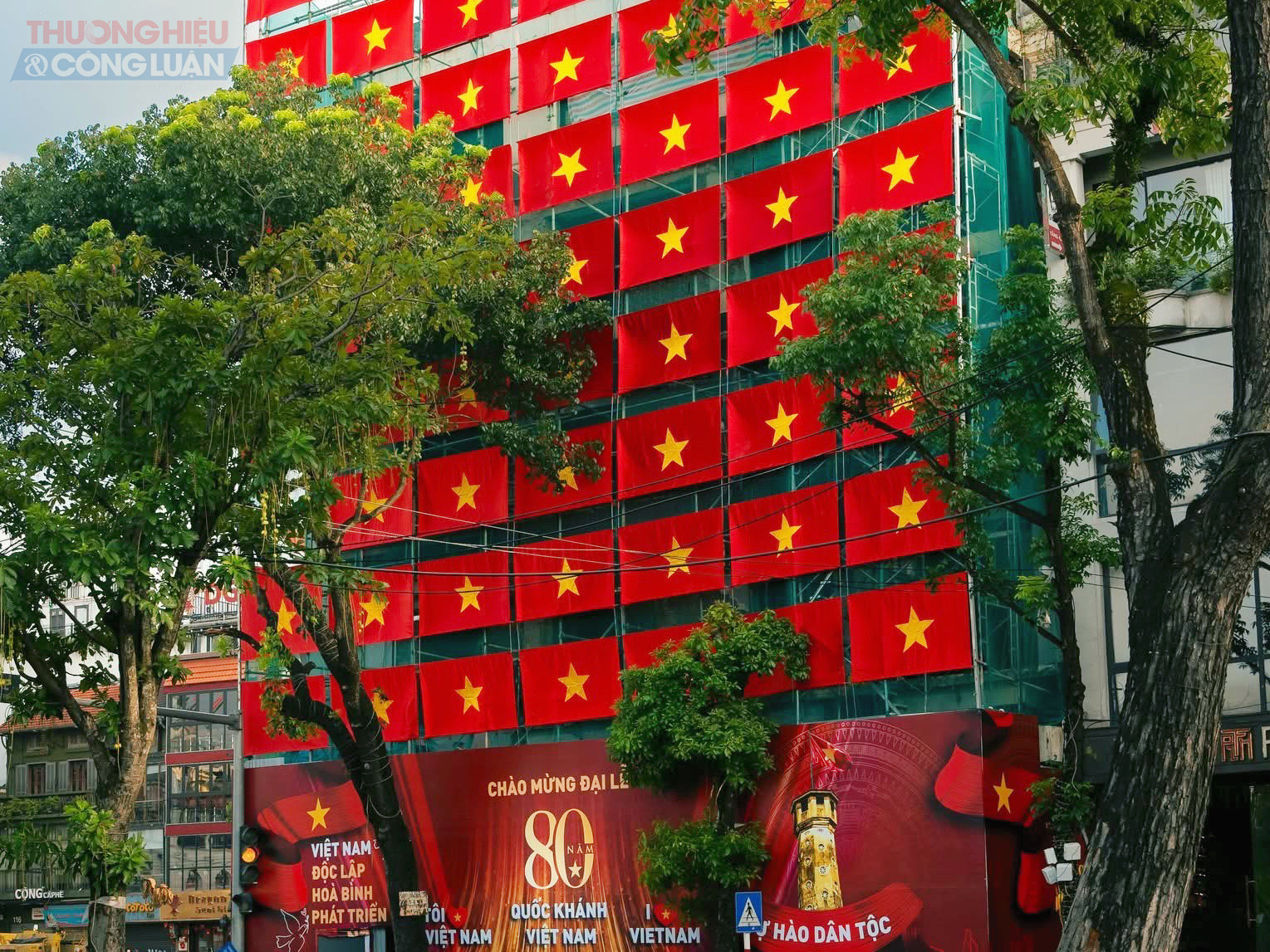 tòa nhà Hàm Cá Mập bên Hồ Gươm dù đang trong quá trình sửa chữa vẫn được khoác lên sắc đỏ rực rỡ của quốc kỳ, trở thành điểm check-in thu hút người dân và du khách.