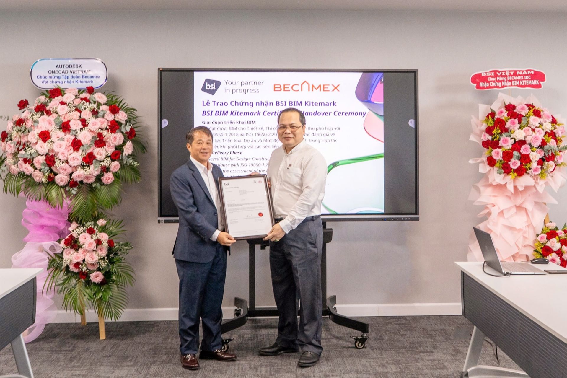 Ông Nguyễn Lê Thi - Trưởng bộ phận Môi trường xây dựng BSI Việt Nam trao trao chứng nhận BSI Kitemark theo tiêu chuẩn ISO 19650 cho ông Nguyễn Việt Đức (áo trắng, bìa phải) – Giám đốc Trung tâm phát triển B.I.M tập đoàn Becamex