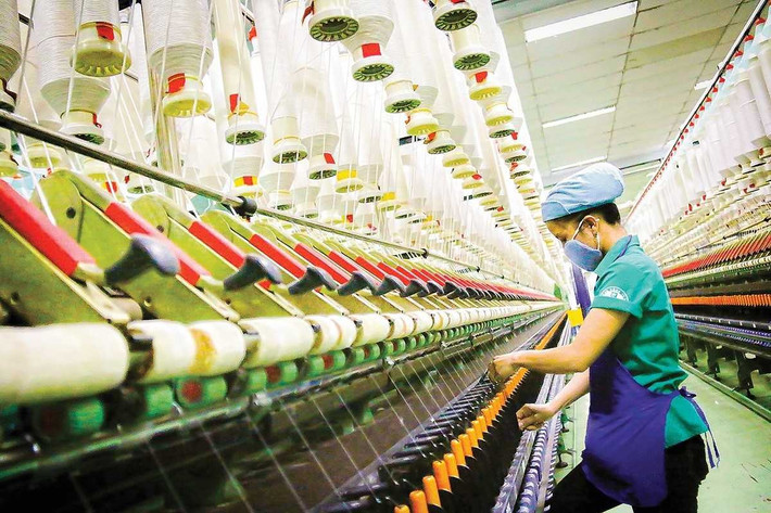 “Công nhân ngành dệt may làm việc trong bối cảnh doanh nghiệp phải đối mặt với thách thức từ các chính sách thuế quan.”