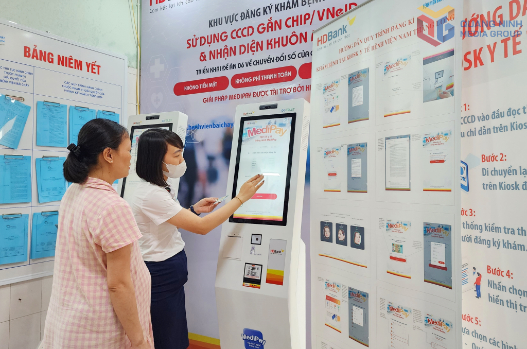 Nhân viên công tác xã hội Bệnh viện Bãi Cháy hướng dẫn người dân đăng ký khám bệnh trên hệ thống ki-ốt thông minh.