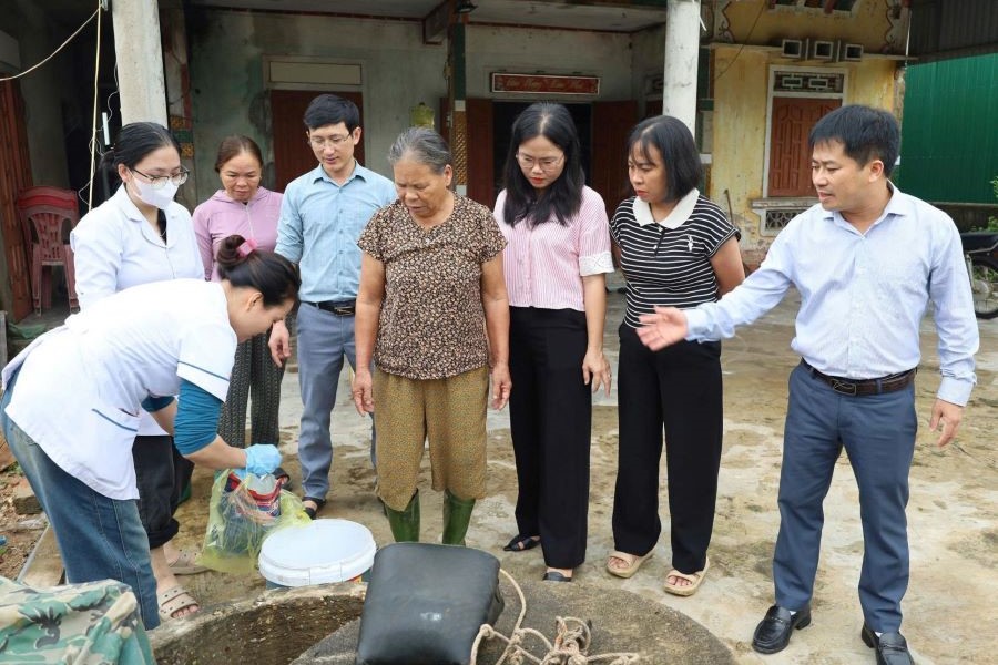 Giám đốc CDC Hà Tĩnh cùng đoàn hướng dẫn xử lý nước sinh hoạt cho người dân xã Cẩm Lạc.