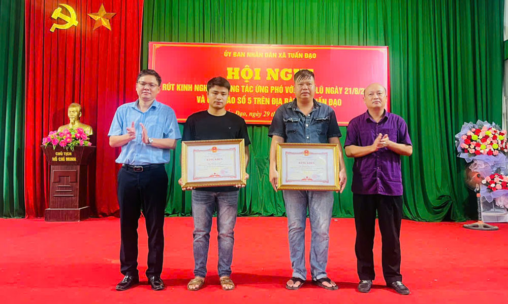 Thừa ủy quyền của Chủ tịch UBND tỉnh, l&atilde;nh đạo x&atilde; Tuấn Đạo trao Bằng khen của Chủ tịch UBND tỉnh cho hai chiến sĩ d&acirc;n qu&acirc;n dũng cảm cứu người trong mưa lũ.