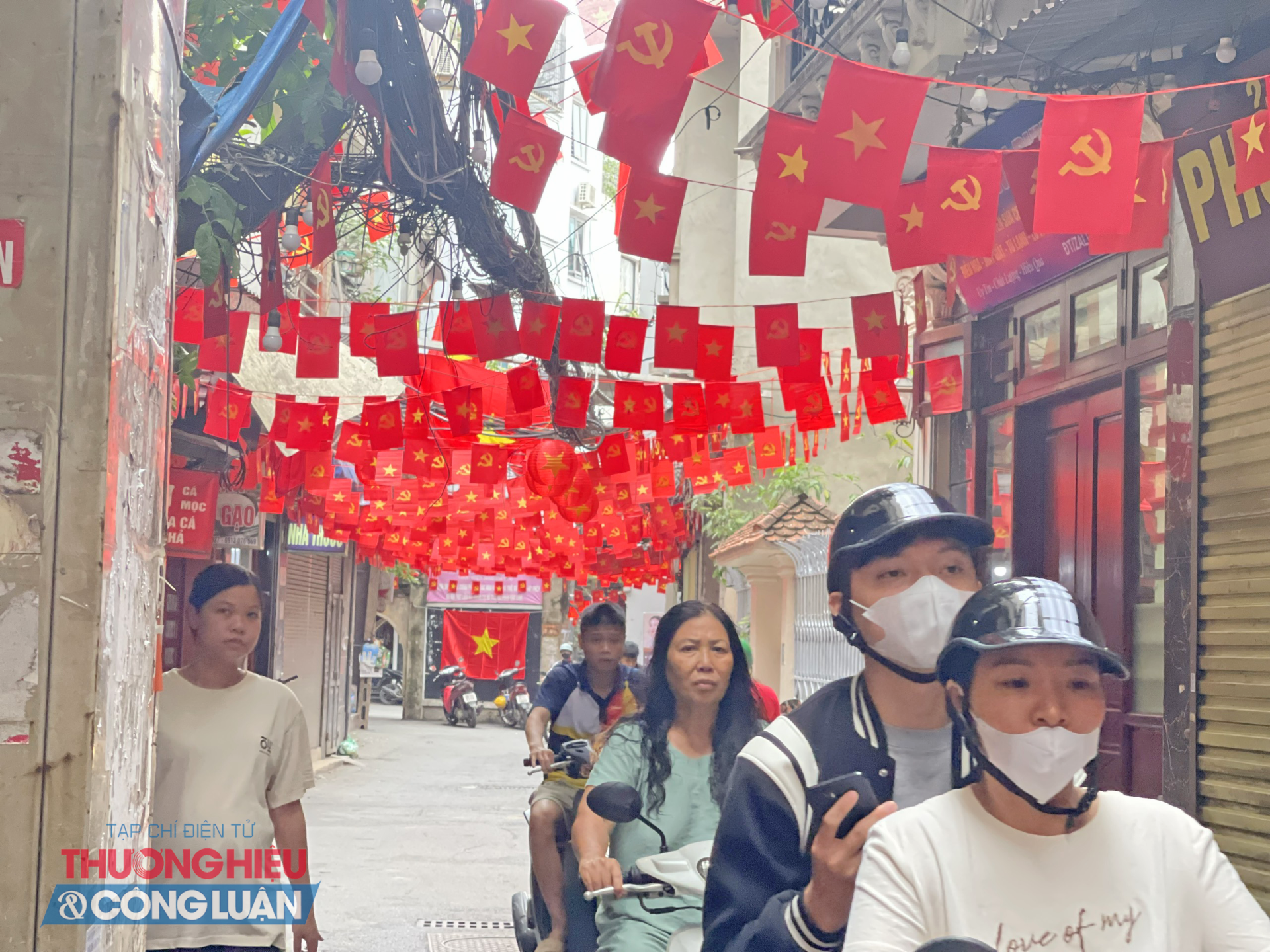 Lá cờ đỏ rợp trời tung bay trong một con ngõ nhỏ thuộc quận Thanh Xuân (Hà Nội), hòa cùng tiếng cười rộn rã của trẻ thơ và nhịp sống bình dị của xóm làng.