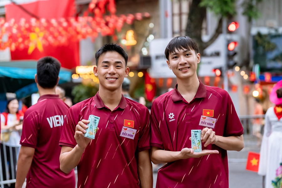 Các đại biểu của Khối Văn hóa – Thể thao tranh thủ tiếp ứng dinh dưỡng trong giờ giải lao. Nước mát, sữa ngon và giàu dinh dưỡng của Vinamilk giúp mọi người tràn đầy năng lượng suốt lễ diễu hành. (Ảnh: Vi Nam)