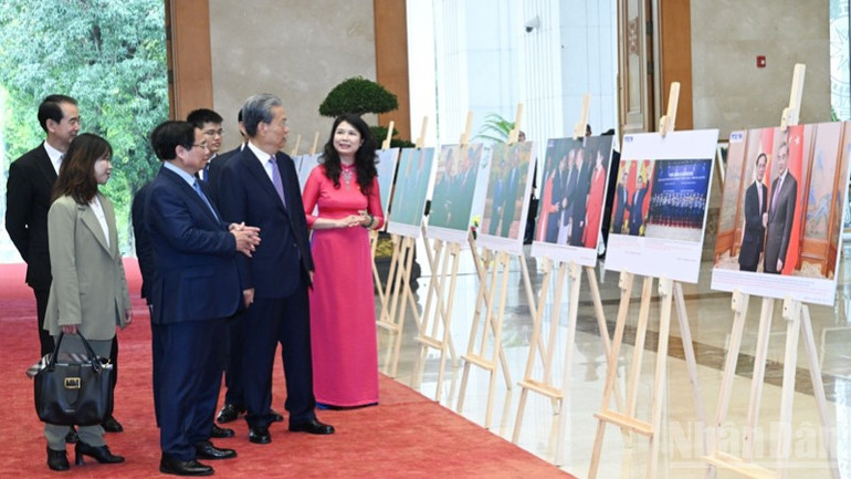 Thủ tướng Phạm Minh Chính giới thiệu với đồng chí Triệu Lạc Tế triển lãm ảnh về quan hệ hữu nghị và hợp tác giữa hai nước. (Ảnh: Trần Hải)