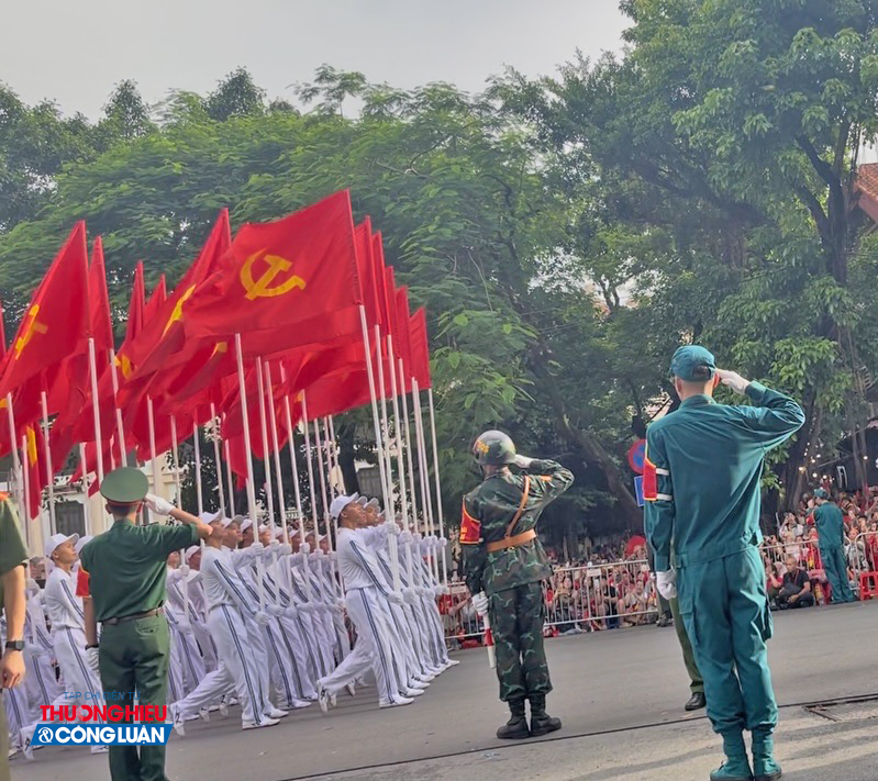 Khối cờ Đảng, cờ Tổ quốc sải bước dứt khoát trên đường Nguyễn Thái Học, phía trên là những lá cờ đỏ thắm tung bay Khối cờ Đảng, cờ Tổ quốc sải bước dứt khoát trên đường Nguyễn Thái Học, phía trên là những lá cờ đỏ thắm tung bay