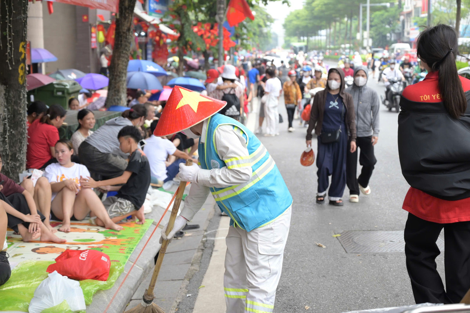 Công nhân thu gom rác trên các trục đường diễu binh A80. Ảnh: Trần Hoàng - Phùng Linh