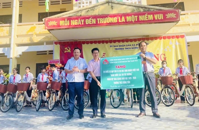 Đại diện lãnh đạo NHCSXH Thanh Hóa trao biểu trưng tặng 20 xe đạp cho học sinh nghèo vượt khó của Trường THCS Đồng Tiến, xã Đồng Tiến.