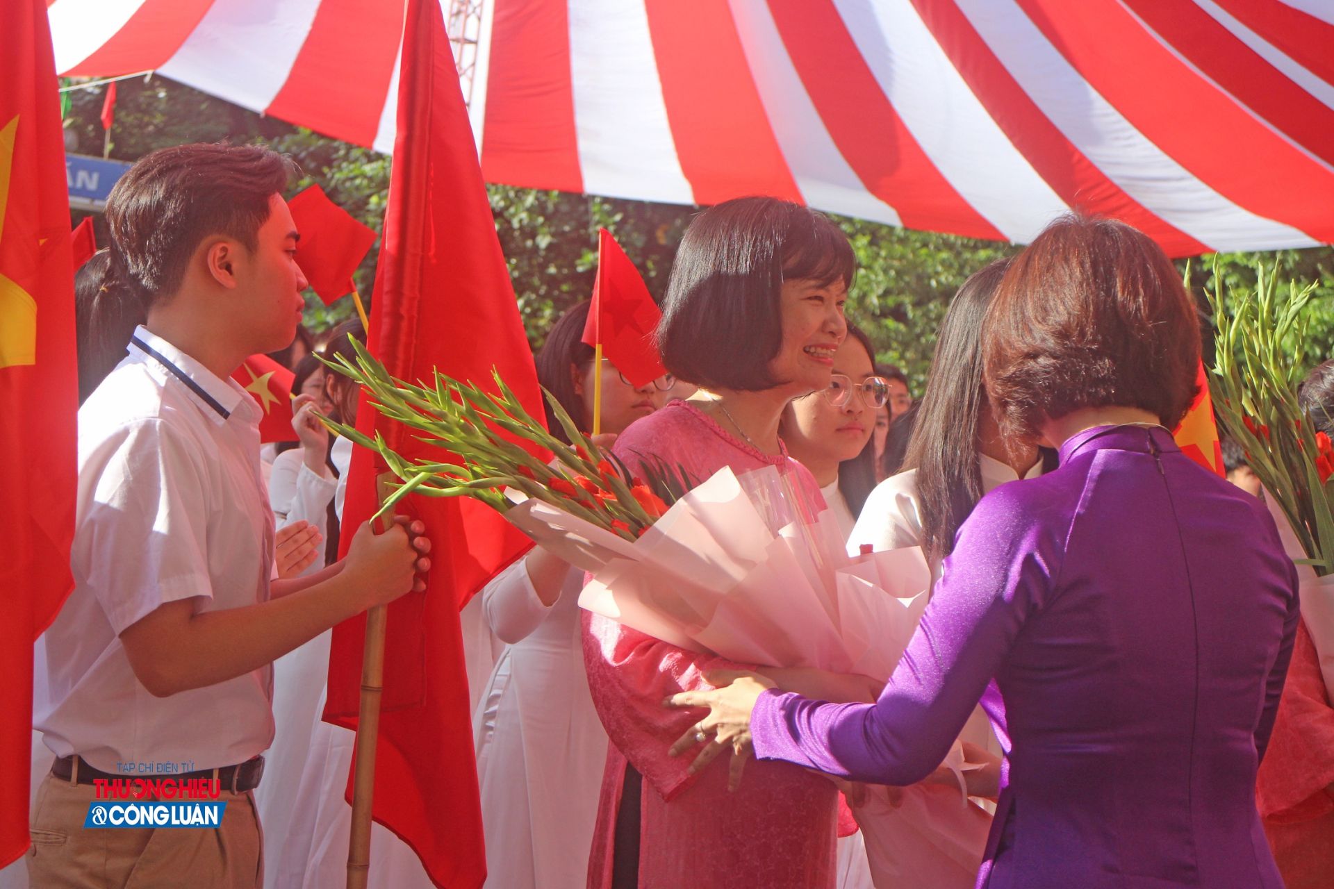 Cô Thuận, giáo viên chủ nhiệm lớp 10A13 nhận hoa chúc mừng từ đại diện nhà trường trong lễ khai giảng.