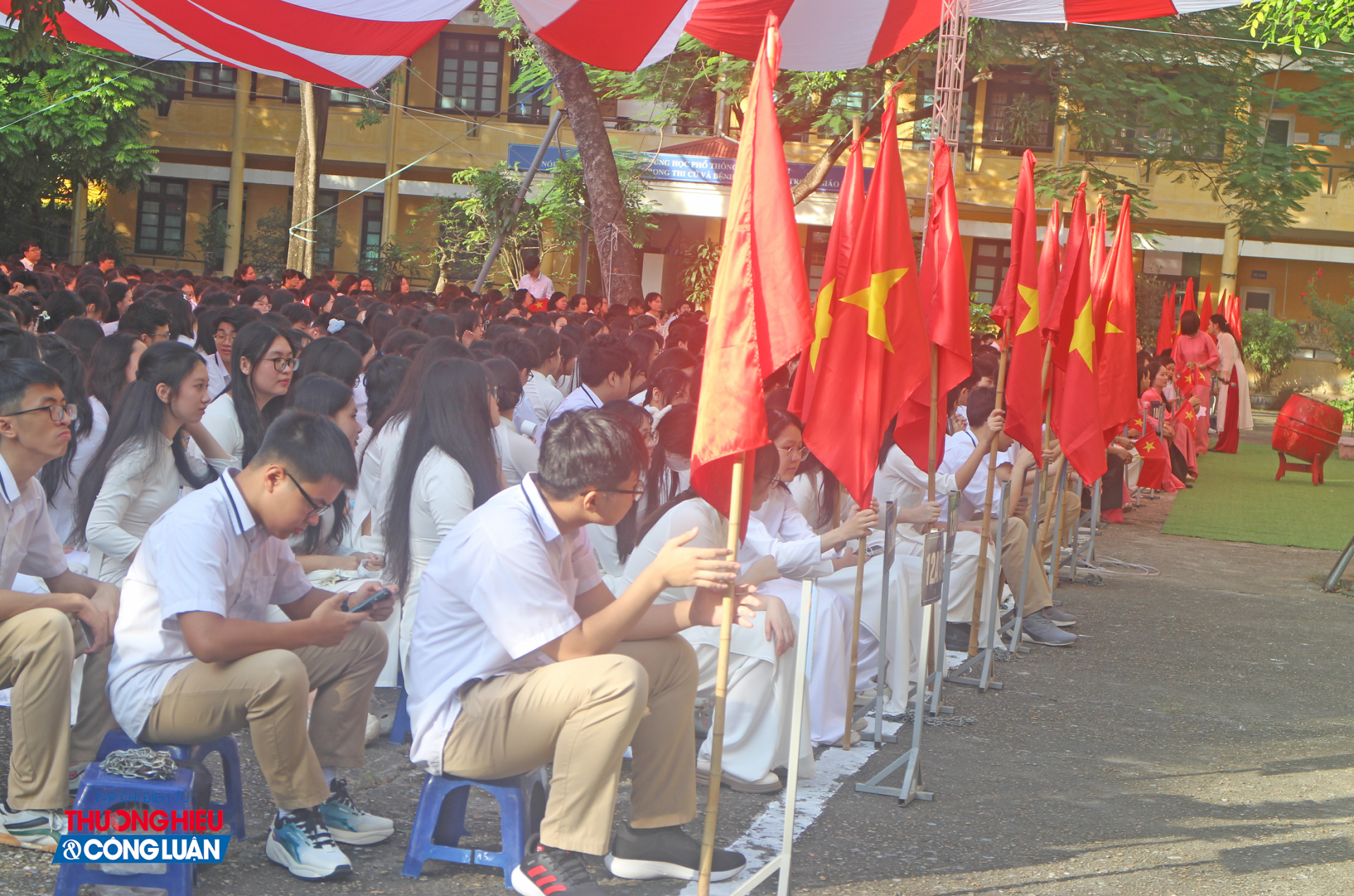 Trước giờ khai giảng, các em học sinh tại trường THPT Nhân Chính háo hức tập trung tại sân trường, rộn ràng trong sắc cờ hoa và tiếng trống chuẩn bị vang lên.