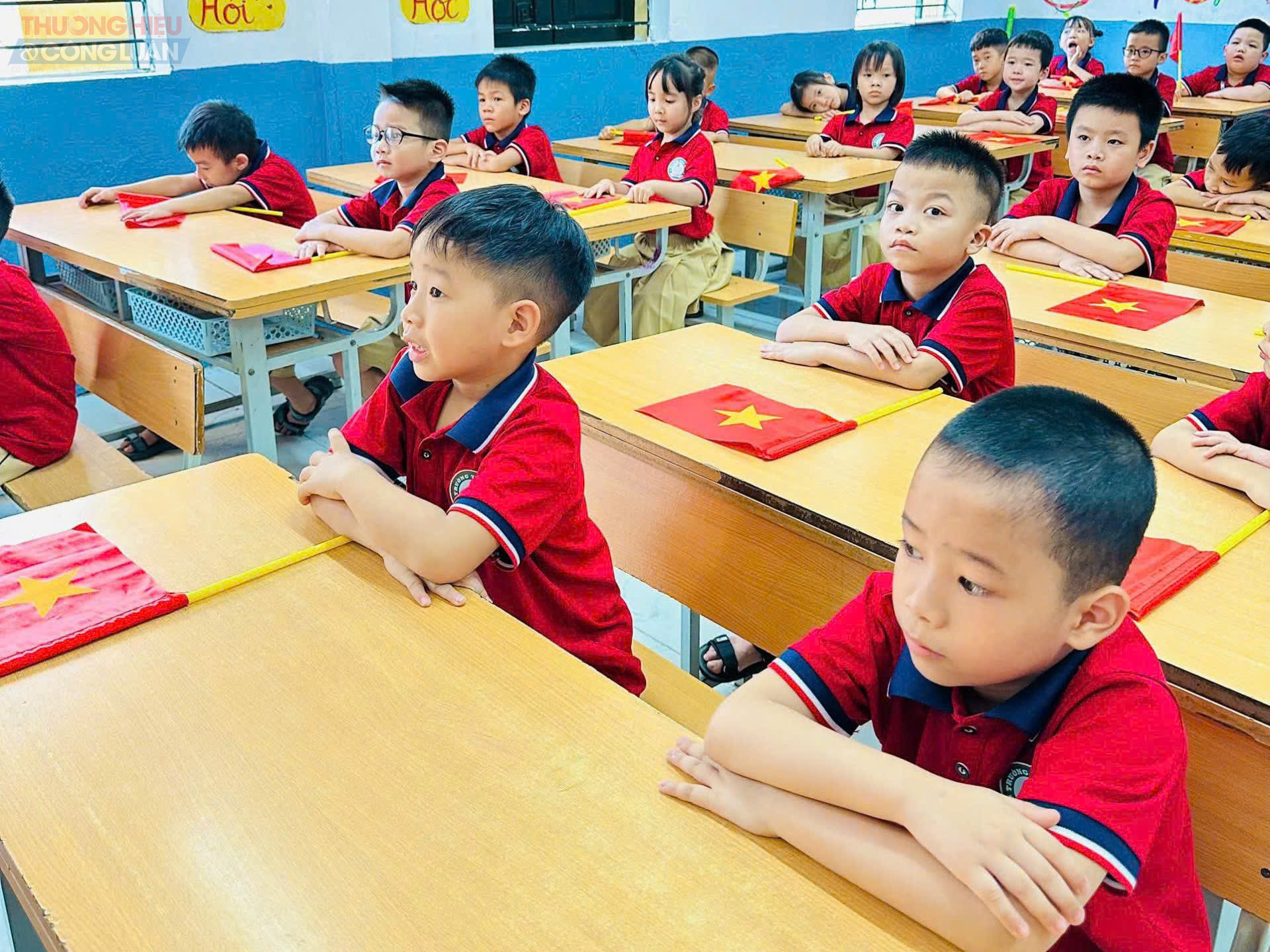 Sắc áo đồng phục hòa cùng cờ đỏ, hoa tươi và những nụ cười trong trẻo tạo nên bầu không khí náo nức của ngày hội toàn dân đưa trẻ đến trường.