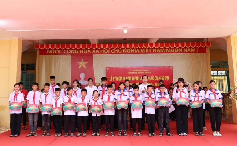 Ông Ngô Đức Bình, Phó Chủ tịch Công đoàn Vietcombank (bên phải) và ông Nguyễn Minh Tuấn, Giám đốc Vietcombank - Chi nhánh Tuyên Quang trao học bổng cho các em học sinh Trường THCS Trung Yên và Trường THCS Kim Quan