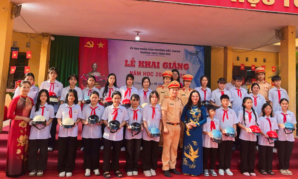 Cán bộ Phòng Cảnh sát giao thông tặng mũ bảo hiểm cho học sinh Trường Trung học cơ sở Trần Phú.