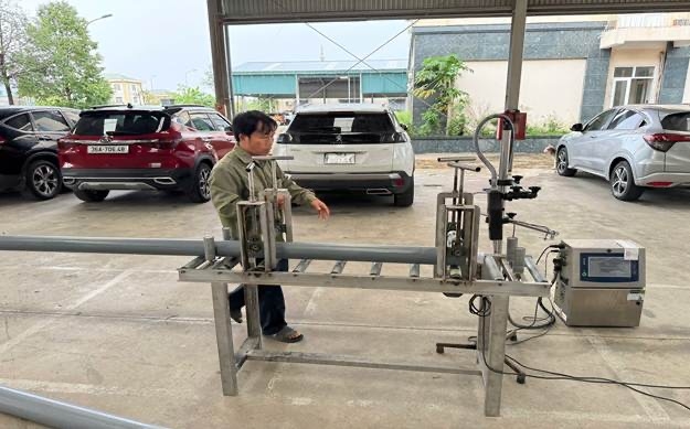 bị can đang tẩy dòng chữ trên ống nhựa của hãng Tiến Phương để phun lên dòng chữ Tiền Phong.