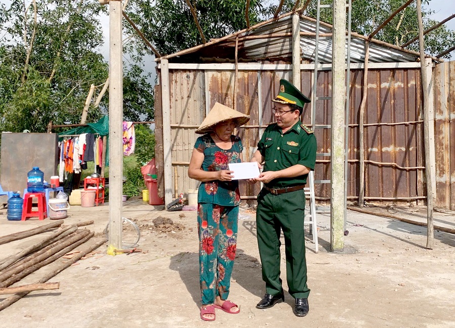Thượng tá Nguyễn Văn Nam - Chính trị viên Đồn Biên phòng Mỹ Thạnh Tây thăm hỏi, trao tiền hỗ trợ hộ gia đình bị thiệt hại nặng do dông lốc